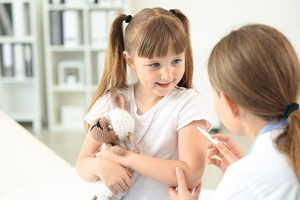 Doctor vaccinating little girl in clinic